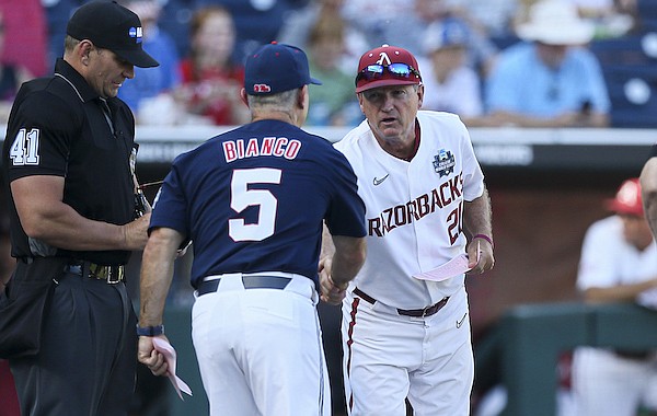 Arkansas coach Dave Van Horn (right) shakes hands with Ole Miss coach Mike Bianco prior to a College World Series game Monday, June 20, 2022, in Omaha, Neb.