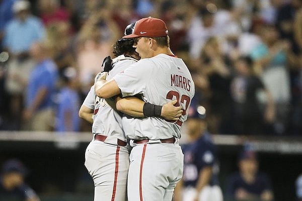Arkansas pitcher Zack Morris hugs catcher Michael Turner after recording the final out of a 3-2 victory over Ole Miss at the College World Series on Wednesday, June 22, 2022, in Omaha, Neb.