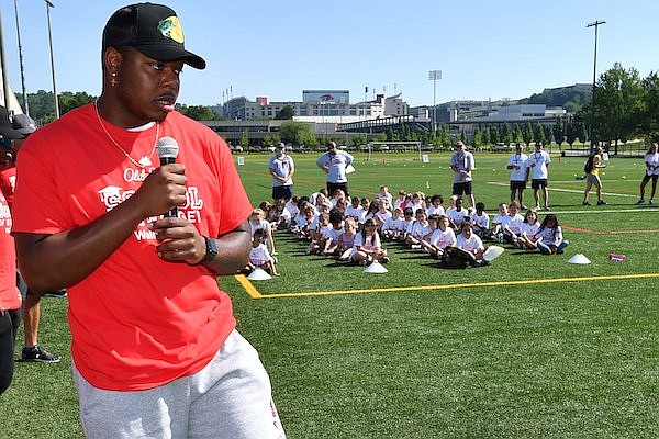 Arkansas quarterback KJ Jefferson (center) speaks to campers Tuesday, June 21, 2022, while working at the Old Spice School of Swagger camp at the University of Arkansas intramural fields in Fayetteville.