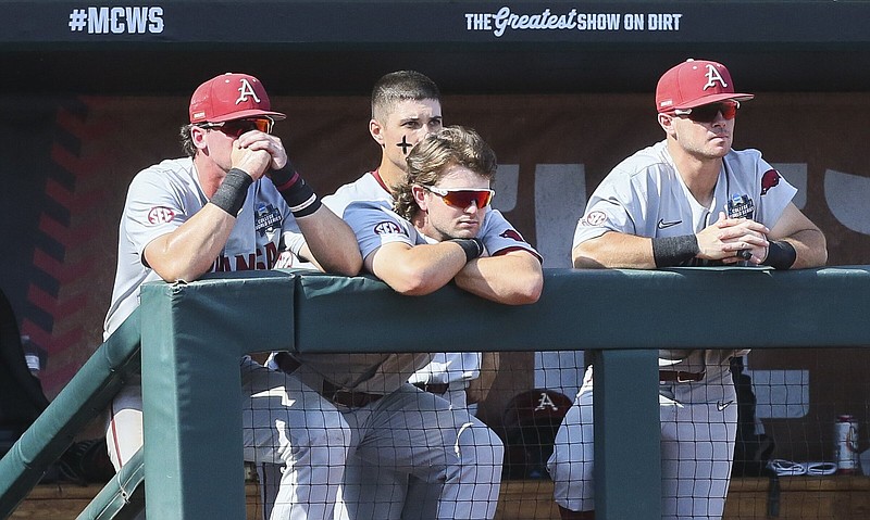 Arkansas players look on as Ole Miss players celebrate Thursday after the Rebels defeated the Razorbacks 2-0 to advance to the championship series of the College World Series at Charles Schwab Field in Omaha, Neb. More photos at arkansasonline.com/624cws/
(NWA Democrat-Gazette/Charlie Kaijo)