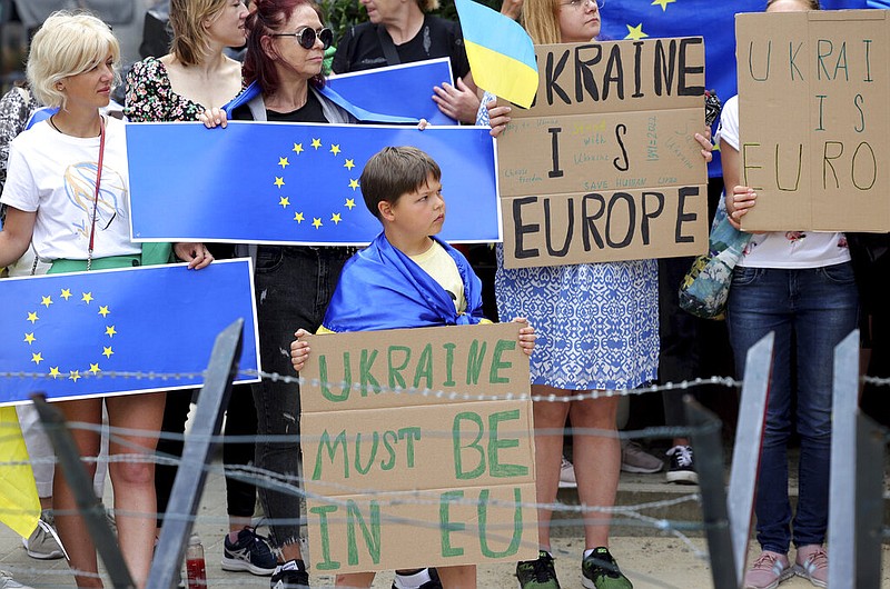 Protestors in support of Ukraine stand with signs and EU flags during a demonstration outside of an EU summit in Brussels, Thursday, June 23, 2022. European Union leaders are expected to approve Thursday a proposal to grant Ukraine a EU candidate status, a first step on the long toward membership. (AP/Olivier Matthys)