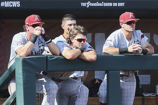 Arkansas players watch as Ole Miss players celebrate a 2-0 victory at the College World Series on Thursday, June 23, 2022, in Omaha, Neb.