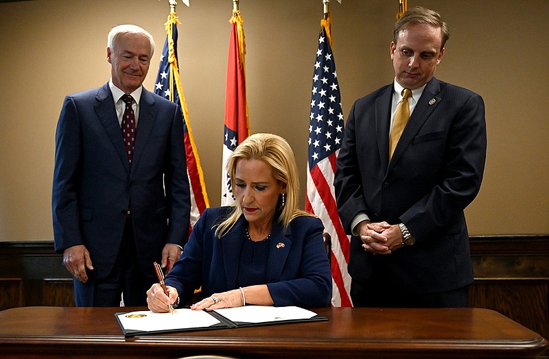 Gov. Asa Hutchinson and House Speaker Matthew Shepherd watch Friday as Arkansas Attorney General Leslie Rutledge signs the state abortion law certification Friday at her office in Little Rock. Hutchinson said he doesn’t plan to ask the Legislature to change the law to provide exemptions in cases of rape or incest. More photos at arkansasonline.com/625roe/.
(Arkansas Democrat-Gazette/Stephen Swofford)