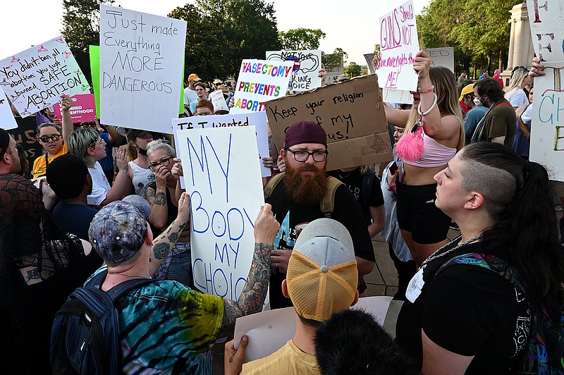 Abortion rights protesters surround counterprotester Allen Nelson (center) as he reads from the Bible during a rally Friday at the state Capitol. State Capitol Police moved him away from the group.
(Arkansas Democrat-Gazette/Stephen Swofford)