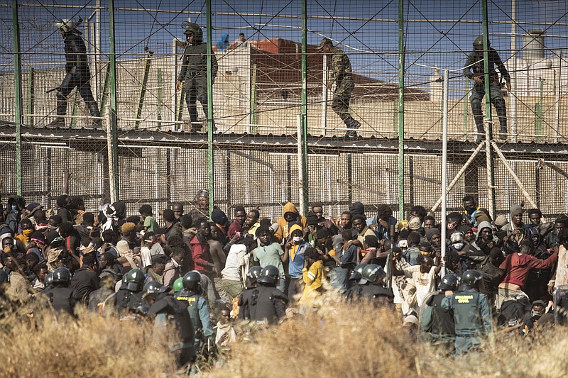 Riot police officers cordon off the area after migrants arrive on Spanish soil and cross the fences separating the Spanish enclave of Melilla from Morocco on Friday in Melilla, Spain.
(AP/Javier Bernardo)