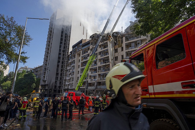 Firefighters work at the scene of a residential building following explosions, in Kyiv, Ukraine, Sunday, June 26, 2022. (AP Photo/Nariman El-Mofty)