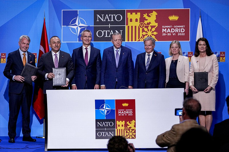 From left to right background: Finnish Foreign Minister Pekka Haavisto, Turkish Foreign Minister Mevlut Cavusoglu, NATO Secretary General Jens Stoltenberg, Turkish President Recep Tayyip Erdogan, Finland's President Sauli Niinisto, Sweden's Prime Minister Magdalena Andersson, and Sweden's Foreign Minister Ann Linde pose for a picture after signing a memorandum in which Turkey agrees to Finland and Sweden's membership of the defense alliance in Madrid, Spain on Tuesday, June 28, 2022. North Atlantic Treaty Organization heads of state will meet for a summit in Madrid from Tuesday through Thursday. (AP Photo/Bernat Armangue)