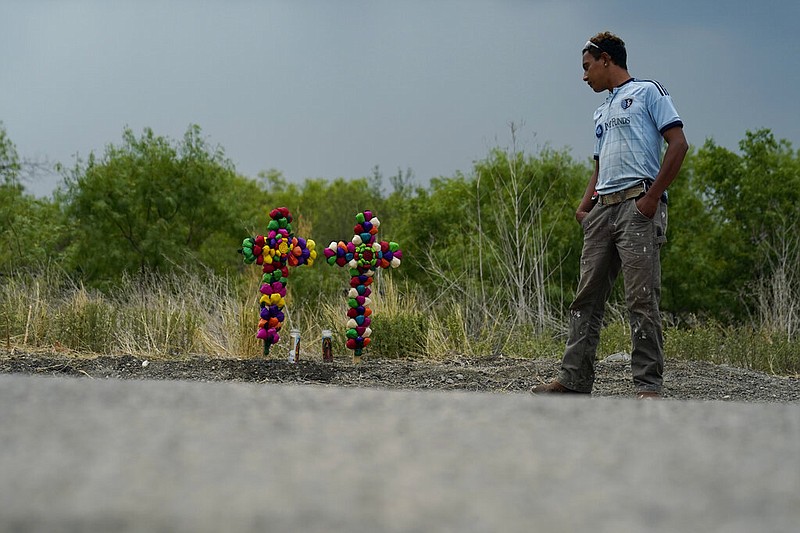 A man pays his respects at the site where officials found dozens of people dead in a semitrailer containing suspected migrants, Tuesday, June 28, 2022, in San Antonio. (AP Photo/Eric Gay)