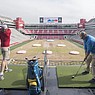 Tye Richardson (left) and Drew Barrett, both of Fort Smith, hit golf balls on Tuesday, May 4, 2022, at Reynolds Razorback Stadium in Fayetteville as part of a preview for the Topgolf Live Stadium Tour. The grass field was damaged following a Garth Brooks concert nearly two weeks earlier, but will not need to be replaced.