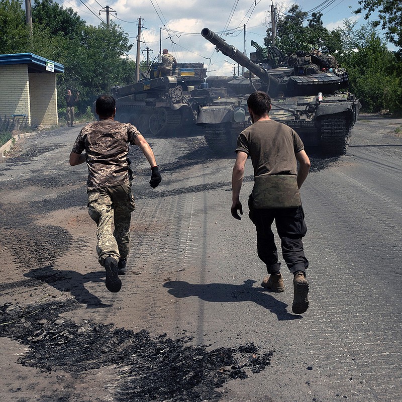 Ukrainian soldiers rush toward a T-64BV tank as it returns from the front line for repairs Wednesday in Bakhmut in eastern Ukraine. More photos at arkansasonline.com/ukrainemonth5/.
(The New York Times/Tyler Hicks)