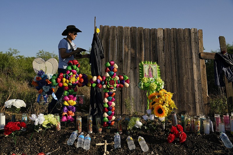 Roberto Marquez of Dallas secures a cross to a make-shift memorial on Wednesday at the site where officials found dozens of people dead in an abandoned semitrailer containing suspected migrants in San Antonio.
(AP/Eric Gay)