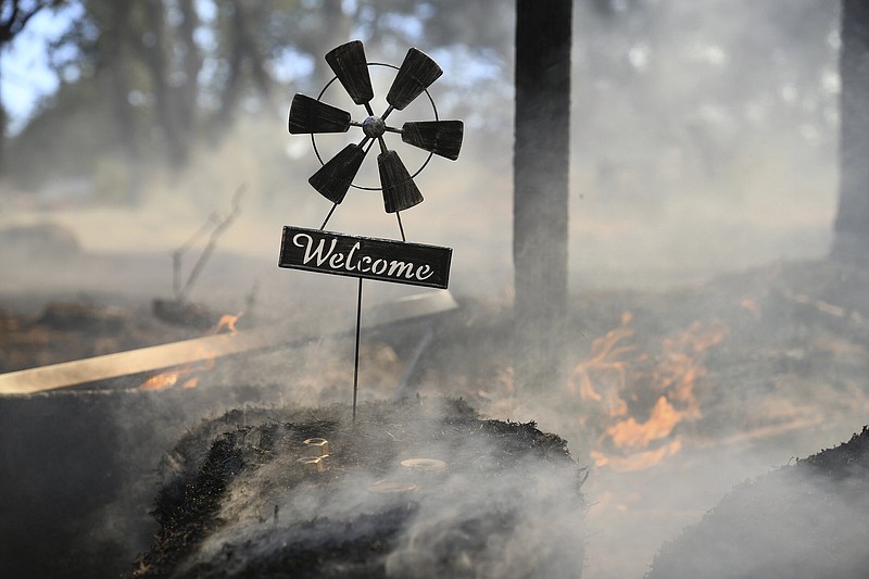 A welcome home sign sits at the front gate of a home along Troost Trail which was saved by firefighters from the Rices Fire on Tuesday in California’s Nevada County.
(AP/The Union/Elias Funez)