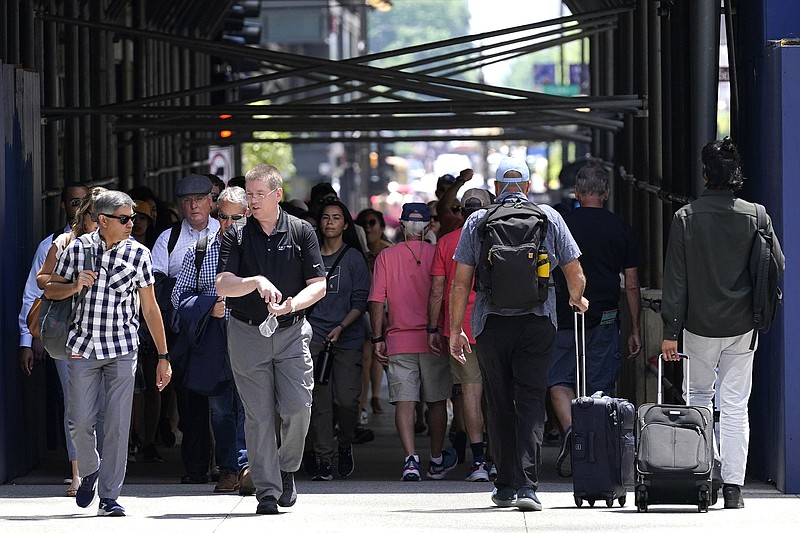 Pedestrians walk along a shopping district Wednesday on Michigan Avenue in downtown Chicago. As most people resume normal life, health officials warn that repeat coronavirus infections are becoming more likely as the virus becomes more contagious as it evolves.
(AP/Nam Y. Huh)