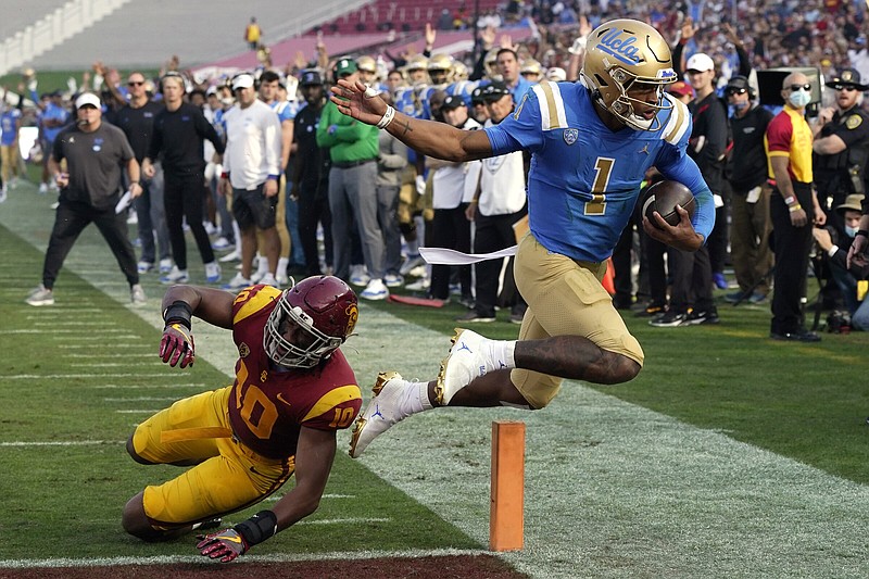 UCLA quarterback Dorian Thompson-Robinson (right) escapes USC linebacker Ralen Goforth for a touchdown last season. The two Pac-12 powerhouses are eyeing a move to the Big Ten, which would greatly enhance their revenue and visibility.
(AP/Mark J. Terrill)