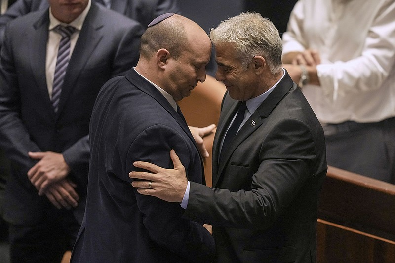 Israeli Prime Minister Naftali Bennett (left) and Foreign Minister Yair Lapid react Thursday after a vote on a bill to dissolve the parliament at the Knesset, Israel’s parliament, in Jerusalem.
(AP/Ariel Schalit)