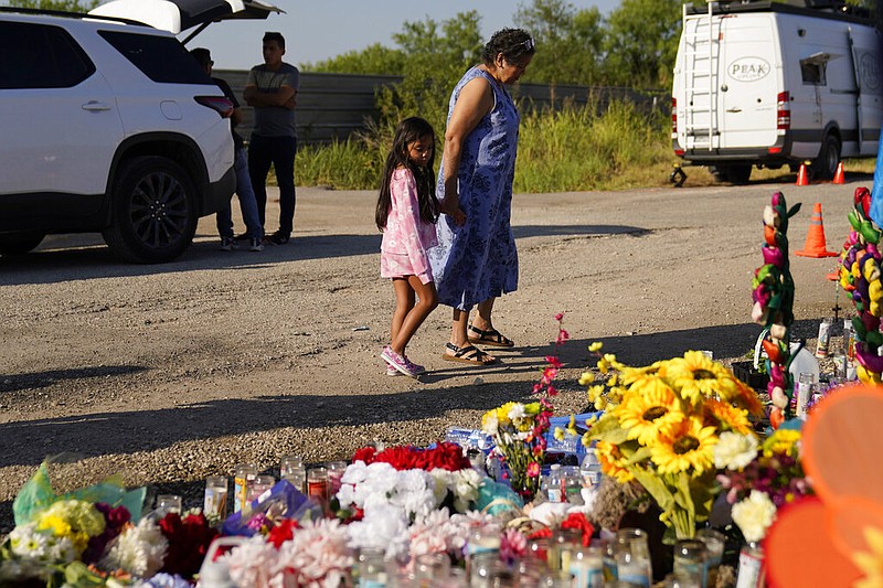 Mourners visit a makeshift memorial Thursday, June 30, 2022, in San Antonio at the site where dozens of suspected migrants died in an abandoned tractor-trailer. (AP/Eric Gay)