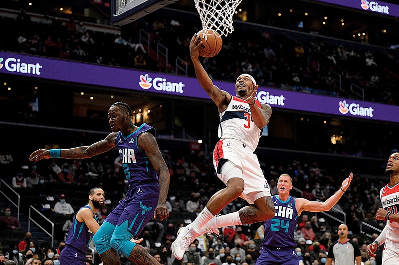 Wizards guard Bradley Beal goes to the basket against Hornets guard Terry Rozier (left) and center Mason Plumlee (24) during the first half of a Jan. 3 game in Washington. The NBA’s free agency period opened Thursday night, with teams and players finally free to negotiate new deals. (Associated Press)