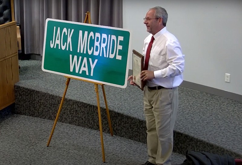 Fulton Mayor Lowe Cannell presents one of the signs that will be placed along West Ninth Street, between Westminster Avenue and Jefferson Street, which the City Council ceremonially designated Jack McBride Way. (Contributed photo)