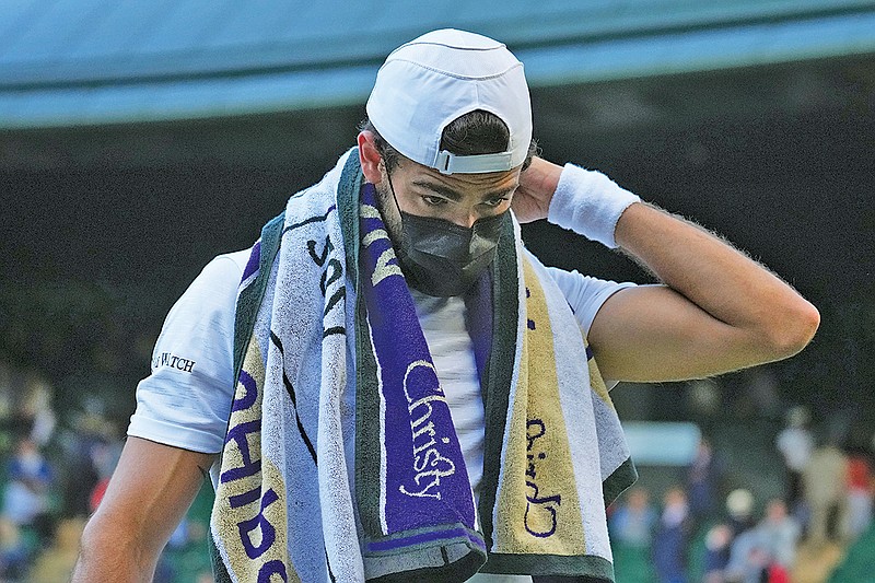 Matteo Berrettini wears a mask at the end of the third set during the men’s singles quarterfinals match against Felix Auger-Aliassime at the Wimbledon Tennis Championships in London on Wednesday. Three of the top 20 seeded men have withdrawn during the first four days at Wimbledon because they got COVID-19. (Associated Press)