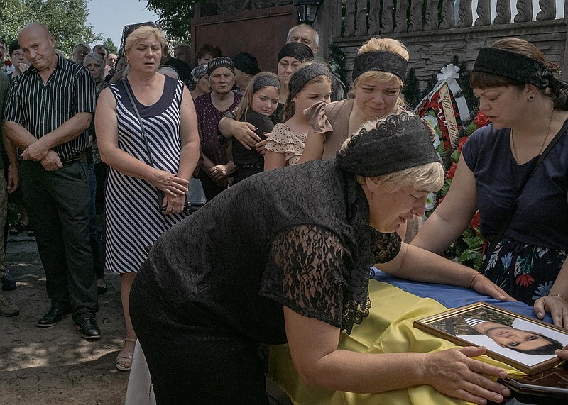 Natalia Dziuba, 46, mourns at the coffin of her husband, Ukrainian Army sergeant Kochetov Volodymyr Petrovich, 45, during his funeral Thursday in Babyntsi, Ukraine. Petrovich, a crew member of an antitank gun, died June 24 in a Russian artillery attack in Kodema village in the Donetsk region of eastern Ukraine.
(The New York Times/Mauricio Lima)