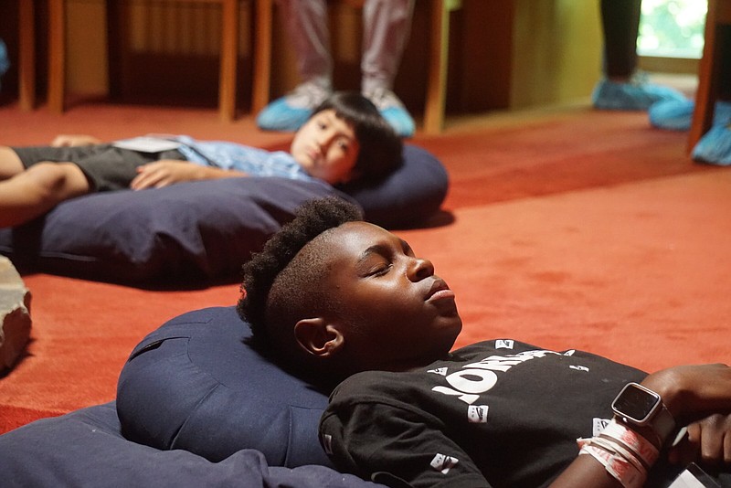 Selah Jones and Scott Dunavant participate in meditation Wednesday at the Arkansas House of Prayer in Little Rock. The two boys attended Interfaith Friendship Camp, learning about various religions throughout the week.
(Photo by Marvin McLennon)