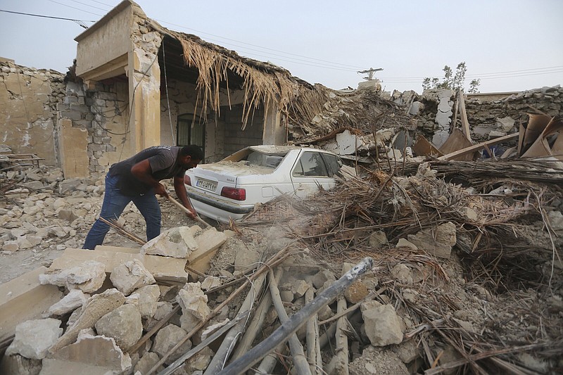 A man cleans up the rubble Saturday after an earthquake hit Sayeh Khosh village in the Hormozgan province of Iran.
(AP/Abdolhossein Rezvani)