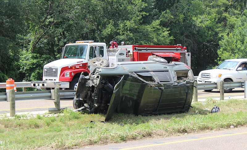 A Ford Expedition lies on its side in the median after it hit a guardrail and rolled over Friday, July 1, 2022, on U.S. Highway 59 in Texarkana, Texas. Kayla Parris, 39, died in the accident after being ejected from the vehicle. The driver was uninjured. (Staff photo)