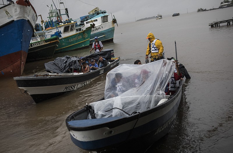 People leave the port by boat to return their communities amid the arrival of Tropical Storm Bonnie in Bluefields, Nicaragua, July 1, 2022. Tropical Storm Bonnie has formed over the Caribbean as it heads for a quick march across Central America and potential development into a hurricane after reemerging in the Pacific.  (AP Photo/Inti Ocon)