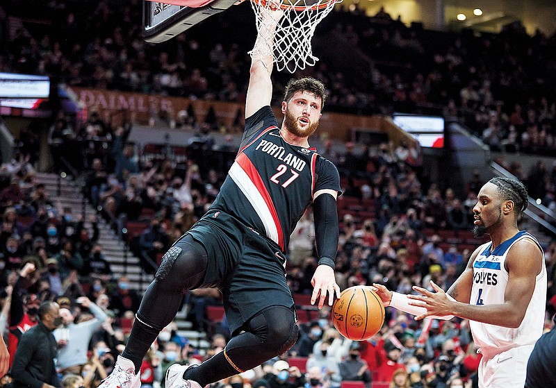 In this Jan. 25 file photo, Trail Blazers center Jusuf Nurkic hangs on the rim after dunking during a game against the Timberwolves in Portland, Ore. (Associated Press)