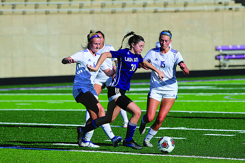 El Dorado's Caroline Meadows tries to get around a pair of defenders in action this season against Hot Springs Lakeside at Memorial Stadium. The senior All-State midfielder has focused on improving her skills this summer during travel ball season.