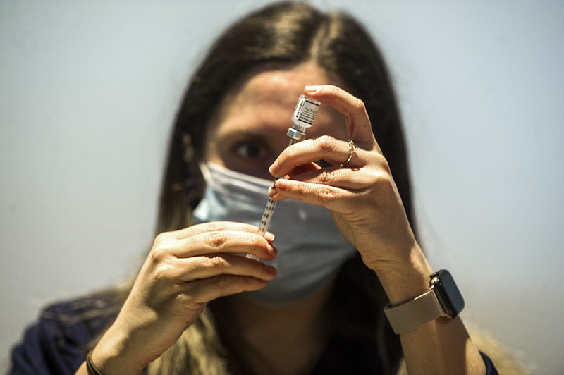 FILE — Rachel Honeycutt, a Pharmacy Technician, draws doses of the covid-19 vaccine during a vaccine clinic at the Mosaic Church on Colonel Glenn Road in Little Rock on Saturday, Jan. 22, 2022. (Arkansas Democrat-Gazette/Stephen Swofford)