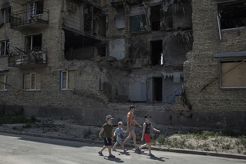 Children walk past a destroyed housing block on Wednesday in Horenko, Ukraine.
(The New York Times/Emile Ducke)