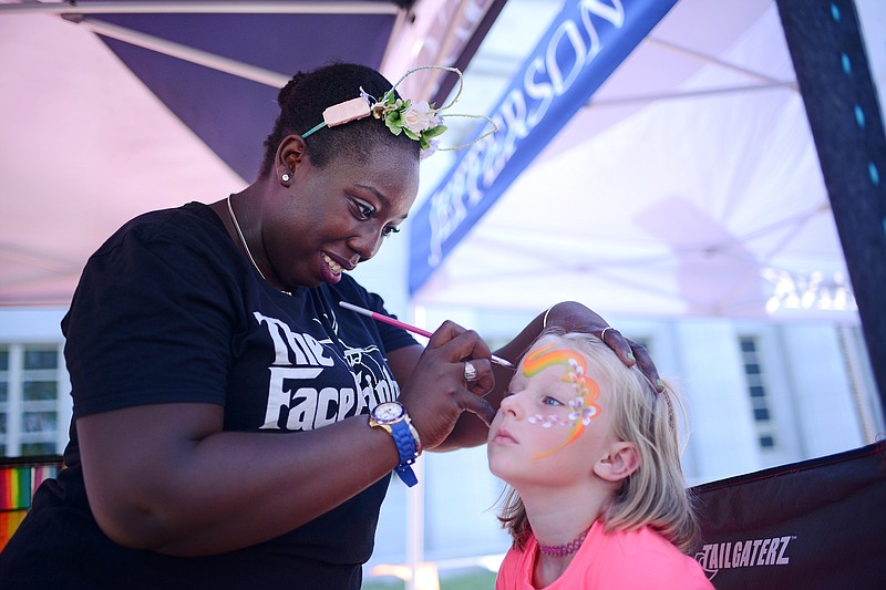Amber Wade, with Island Breeze Face & Body Art, paints a rainbow with flowers on Sawyer Judd, 5, on Friday, July 12, 2019, at the Fifth Annual Ice Cream Splash in Jefferson City. (Sally Ince/News Tribune file photo)