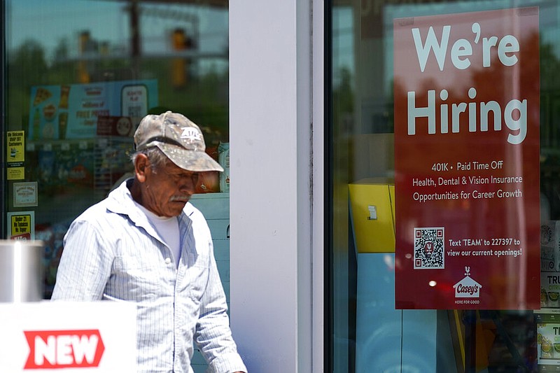A hiring sign is displayed at a gas station as a customer walks past in Buffalo Grove, Ill., Thursday, June 9, 2022. (AP/Nam Y. Huh)