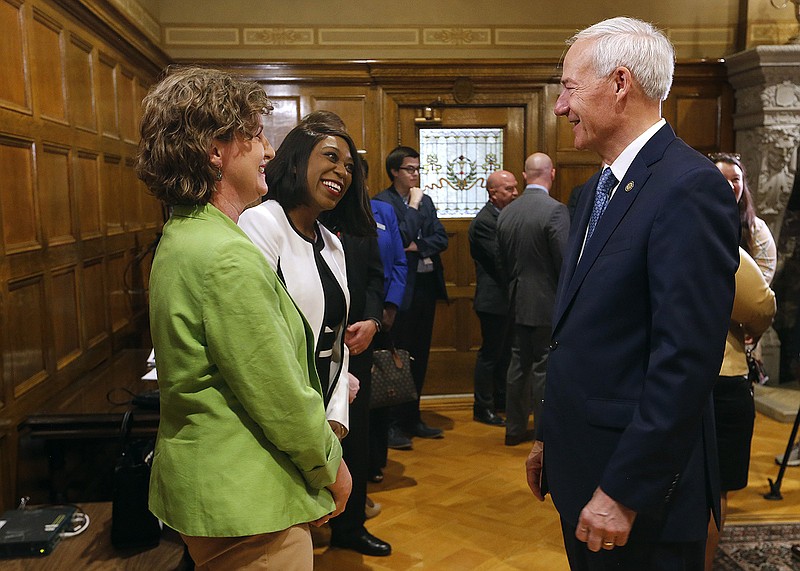 Gov. Asa Hutchinson (right) talks with Henderson State alum Lisa Mundy (left) of Bryant and Henderson vice chancellor of academic affairs and chief learning officer Talisha Givan (center) after a press conference on Thursday at the state Capitol in Little Rock.
(Arkansas Democrat-Gazette/Thomas Metthe)