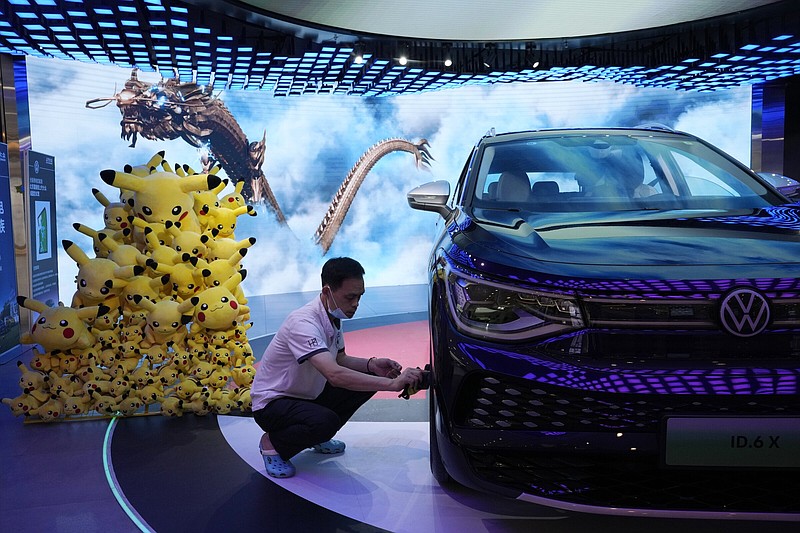 A worker cleans the wheel of an ID electric car displayed at a Volkswagen store Friday in Beijing.
(AP/Ng Han Guan)
