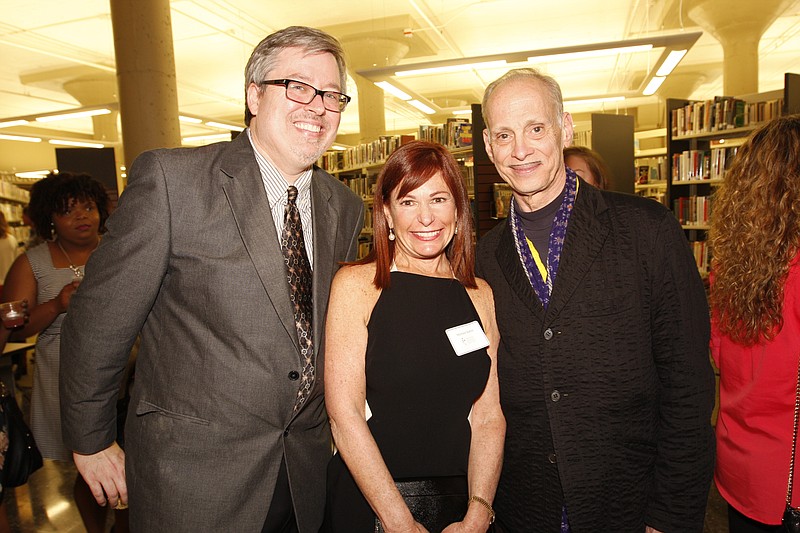 John Waters (right) joins Six Bridges Book Festival coordinator Brad Mooy and Michele Raffin at a reception in April 2015. (Democrat-Gazette file photo)