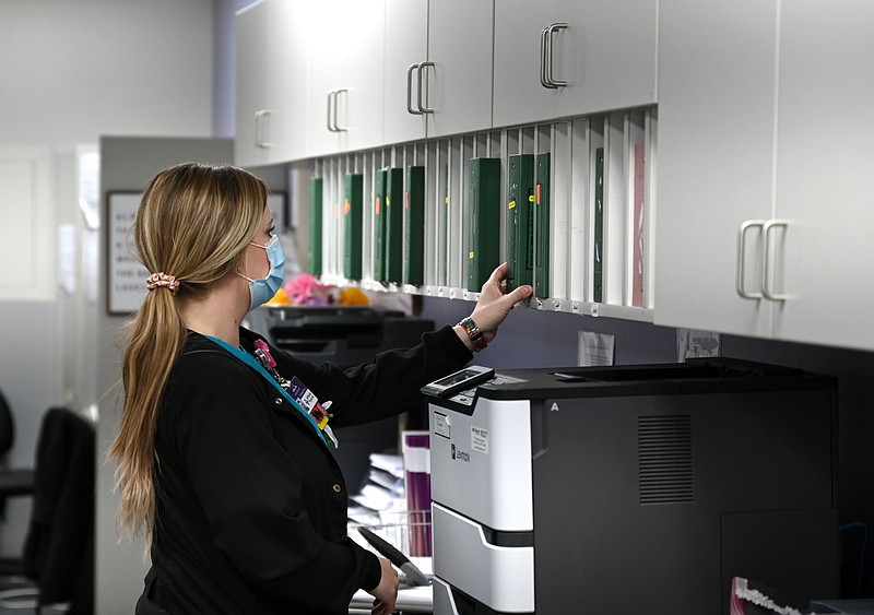 Ashley Cannon, a registered nurse at Jefferson Regional Medical Center in Pine Bluff, walks to her desk from a patient's room in the covid ward of the hospital on Friday, Feb. 18, 2022. (Arkansas Democrat-Gazette/Stephen Swofford)