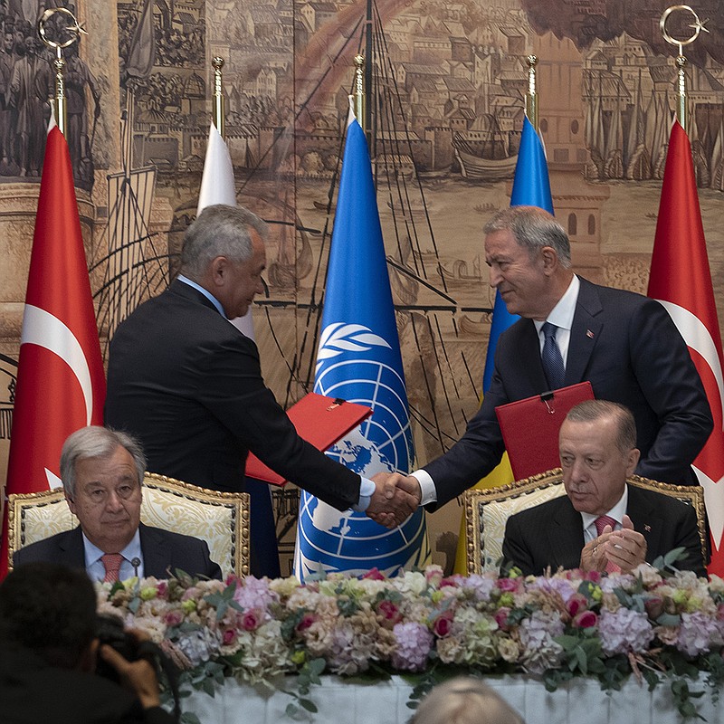 Defense ministers Sergei Shoigu (left) of Russia and Hulusi Akar of Turkey shake hands Friday at Dolmabahce Palace in Istanbul as U.N. Secretary General Antonio Guterres (sitting left) and Turkish President Recep Tayyip Erdogan oversee the signing ceremony. “This agreement did not come easy,” Guterres said. More photos at arkansasonline.com/ukrainemonth5/.
(AP/Khalil Hamra)