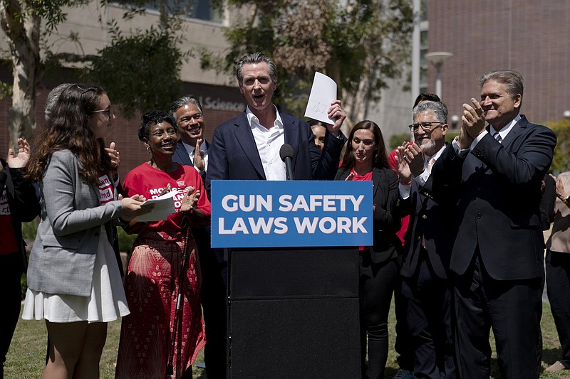 California Gov. Gavin Newsom (center) celebrates Friday at Santa Monica College campus in Santa Monica, Calif., after singing a gun control law. Newsom is surrounded by state officials including state Sen. Bob Hertzberg (right), state Sen. Anthony Portantino (second right), Attorney General Rob Bonta (third left) and gun violence survivors, Mia Tretta and Arvis Jones.
(AP/Jae C. Hong)