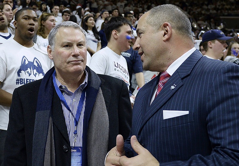 In this Feb. 13, 2017, file photo, American Athletic Conference commissioner Mike Aresco, left, talks with Connecticut athletic director David Benedict, right, before an NCAA college basketball game between UConn and South Carolina in Storrs, Conn. 
(AP Photo/Jessica Hill, File)