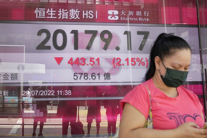 A woman walks past a bank’s electronic board showing the Hong Kong share index in Hong Kong, Friday.
(AP/Kin Cheung)