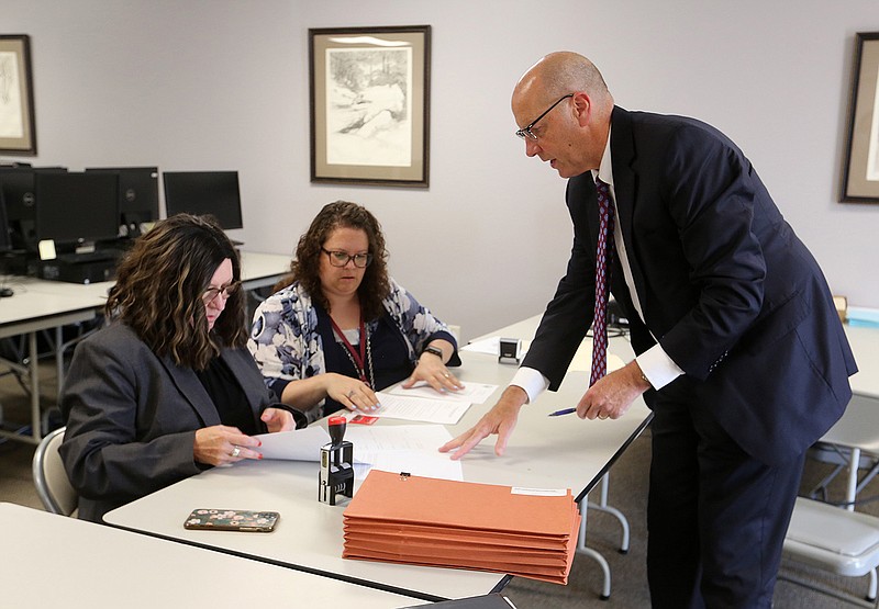 Steve Lancaster, counsel for Responsible Growth Arkansas, turns in petition signatures July 8 to Leslie Bellamy (left), director of elections, and Shantell McGraw at the secretary of state’s office. Officials reported verification of 90,000 signatures Thursday, putting the group’s proposed constitutional amendment to legalize recreational marijuana a step closer to getting on the Nov. 8 ballot.
(Arkansas Democrat-Gazette/Thomas Metthe)