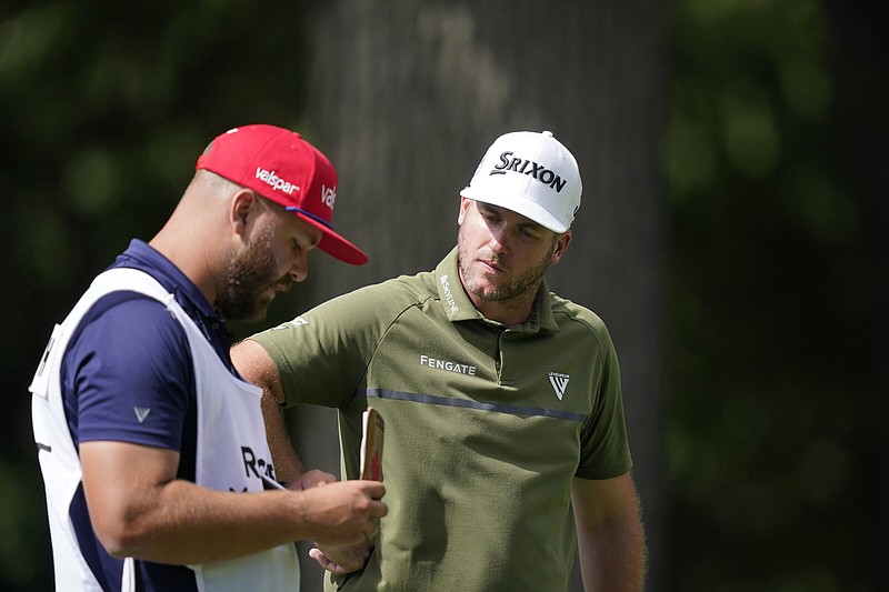 Taylor Pendrith (right) talks to his caddie on the 11th hole Friday during the second round of the PGA Tour’s Rocket Mortgage Classic in Detroit. Pendrith shot a 7-under 65 and holds a one-stroke lead over Tony Finau going into today’s third round.
(AP/Carlos Osorio)