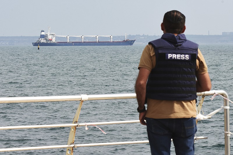 A journalist watches as the bulk carrier Razoni starts its way from the port in Odesa, Ukraine, Monday, Aug. 1, 2022. According to Ukraine's Ministry of Infrastructure, the ship under Sierra Leone's flag is carrying 26 thousand tons of Ukrainian corn to Lebanon. The first ship carrying Ukrainian grain set off from the port of Odesa on Monday under an internationally brokered deal and is expected to reach Istanbul on Tuesday, where it will be inspected, before being allowed to proceed. (AP Photo/Michael Shtekel)