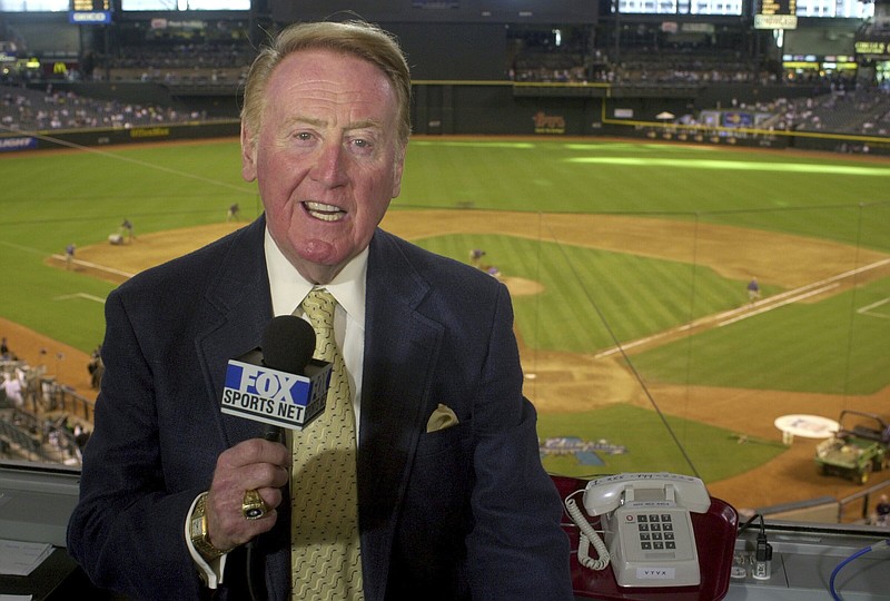Los Angeles Dodgers television play-by-play announcer Vin Scully rehearses before a baseball game between the Dodgers and the Arizona Diamondbacks in Phoenix on July 3, 2002. Scully, whose dulcet tones provided the soundtrack of summer while entertaining and informing Dodgers fans in Brooklyn and Los Angeles for 67 years, died Tuesday night, Aug. 2, 2022, the team said. He was 94. 
(AP Photo/Paul Connors, File)