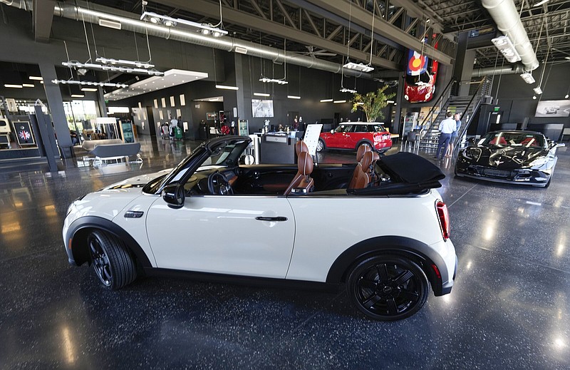A sales associate talks with a prospective buyer of a Cooper SE electric vehicle on the showroom floor of a Mini dealership in Highlands Ranch, Colo., in July. Automakers are critical of the plan offered by Democrats to reduce the price of electric vehicles.
(AP)