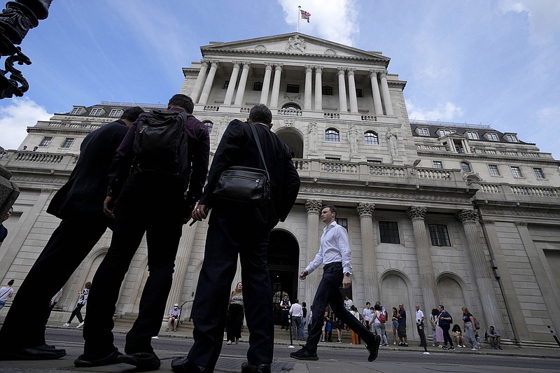 People stand outside the Bank of England in London on Thursday. The central bank approved a half-point interest rate increase, the biggest rise in 27 years.
(AP/Frank Augstein)