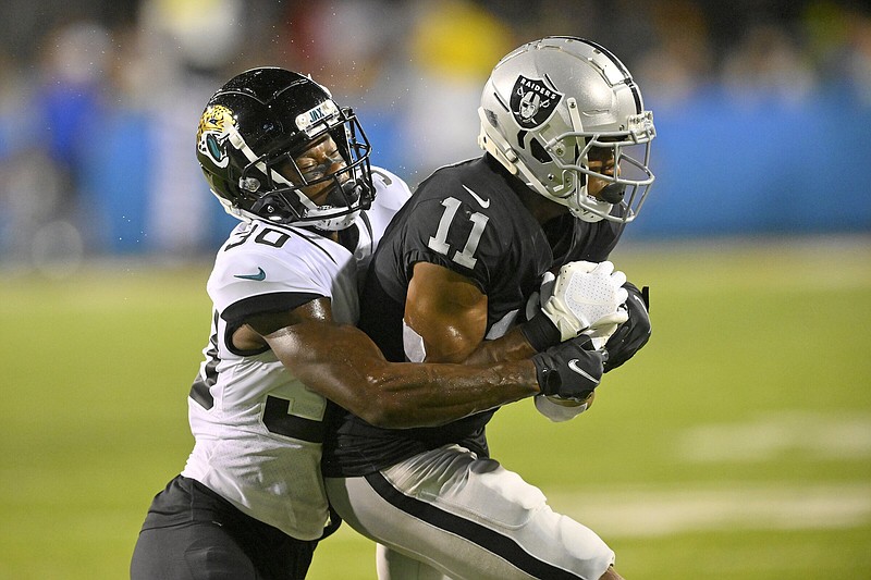 Las Vegas Raiders wide receiver Demarcus Robinson (11) is wrapped up by former Arkansas defensive back Montaric Brown of the Jacksonville Jaguars during the first half of Thursday night’s Hall of Fame Game in Canton, Ohio. More photos available at arkansasonline.com/85nfl22/.
(AP/David Richard)
