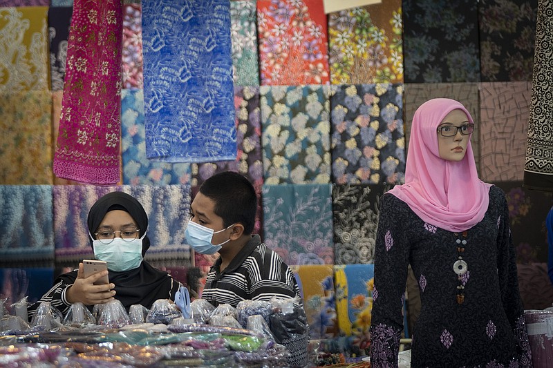 A Muslim couple shops for clothes in Kuala Lumpur, Malaysia, in this file photo. Asia-Pacific economies are expected to slow this year because of inflation, geopolitical uncertainties and the covid-19 pandemic.
(AP)